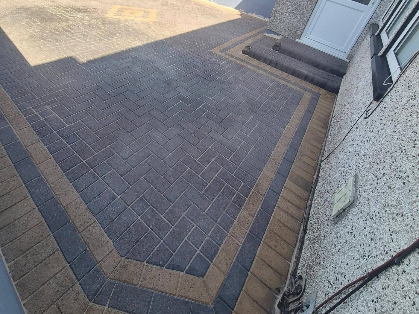 Herringbone block-paved driveway after pressure washing