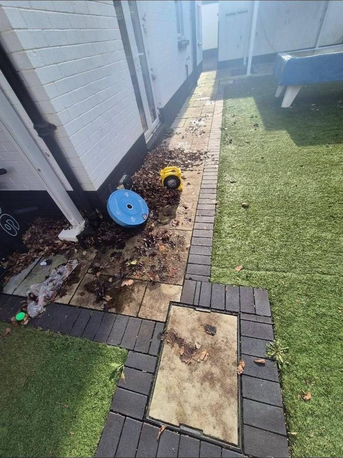 Leaf-covered side path before cleaning